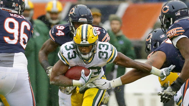 Green Bay Packers running back Aaron Jones (33) runs through defenders for a gain during the first quarter against the Chicago Bears on Nov. 12, 2017, at Soldier Field in Chicago.