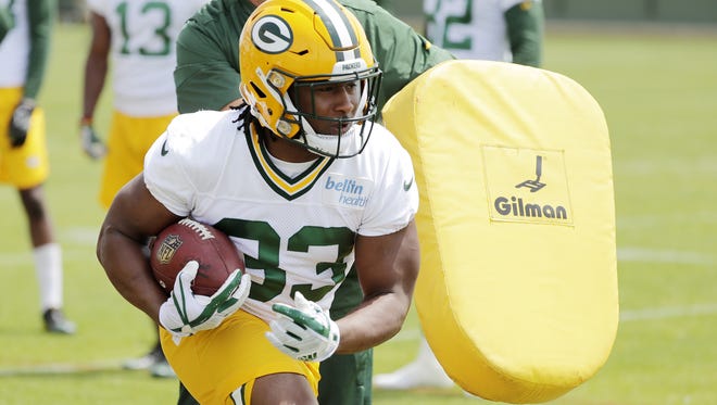 Green Bay Packers running back Aaron Jones (33) runs through a drill during minicamp on June 14, 2018, at Ray Nitschke Field.