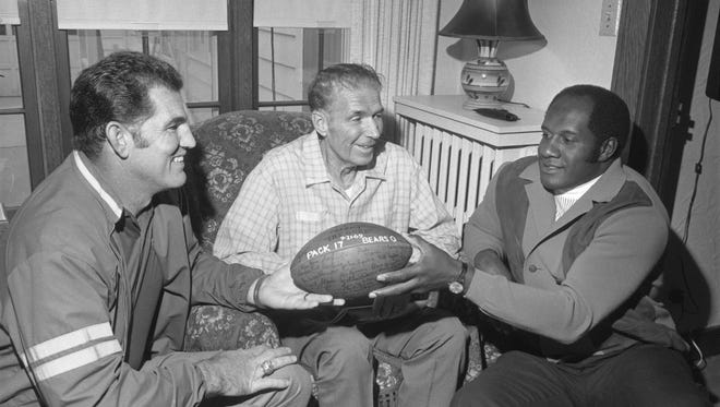 Green Bay Packers teammates Forrest Gregg and Willie Davis presented a game ball to former Packers player Arnie Herber in September 1969. A Green Bay native, Herber joined the team in 1930 and played 11 seasons with the Packers. He was inducted into the Pro Football Hall of Fame in 1966. .