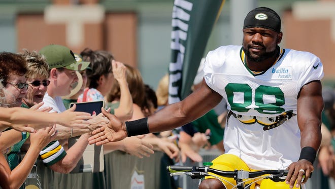 Green Bay Packers running back Ty Montgomery high-fives fans on his way to a 2017 training camp practice.
