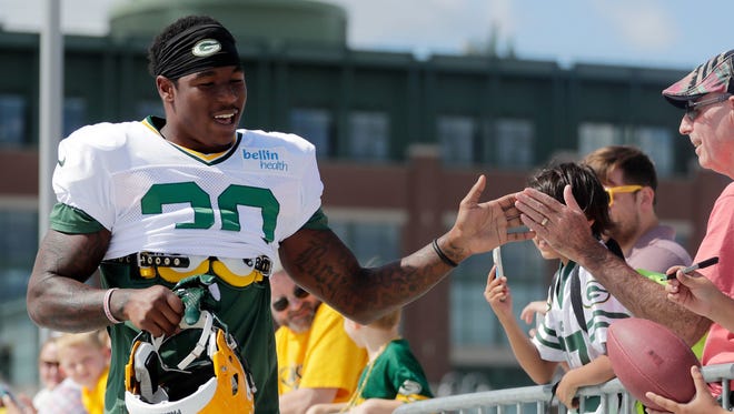 Green Bay Packers running back Jamaal Williams (30) high fives fans on his way to training camp practice on Aug. 22, 2017, at Ray Nitschke Field.