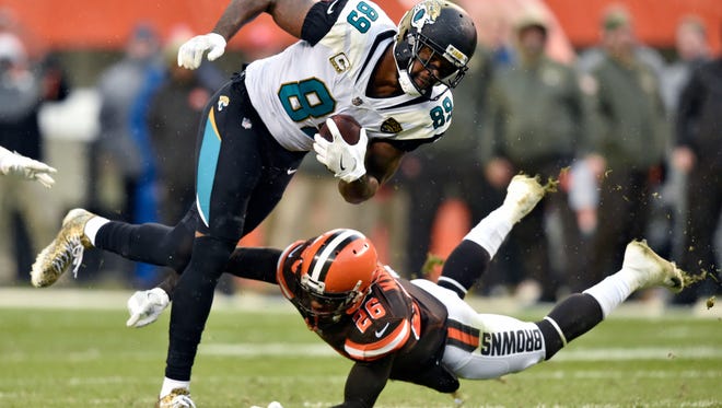 Jacksonville Jaguars tight end Marcedes Lewis (89) is tackled by Cleveland Browns strong safety Derrick Kindred (26) in the first half of an NFL football game, Sunday, Nov. 19, 2017, in Cleveland.