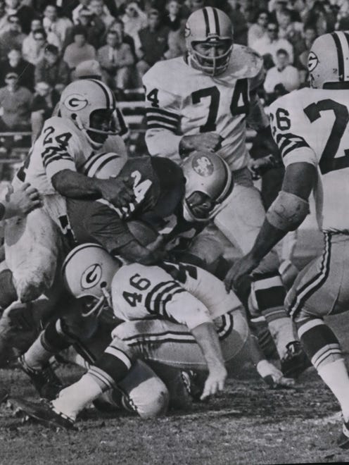 Packers safety Willie  Wood (24) is joined by teammates Hank Gremminger (46), Henry Jordan (74) and Herb Adderley (26) as they try to bring down San Francisco fullback Joe Perry during a game in 1963. Green Bay won, 21-17.
