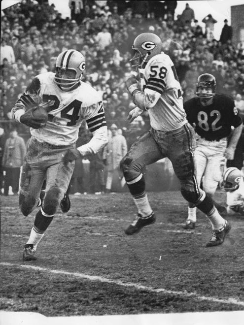 Willie Wood (24) cuts to his protective alley on a 64-yard punt return at Wrigley Field in 1964. Wood's teammate Dan Currie (58) Wood broke the game open with two big returns for 106 yards.