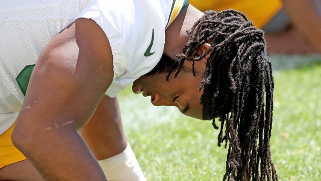 Green Bay Packers running back Aaron Jones (33) stretches during minicamp practice on June 13. Jones has been suspended by the NFL for the first two games of the 2018 regular season.