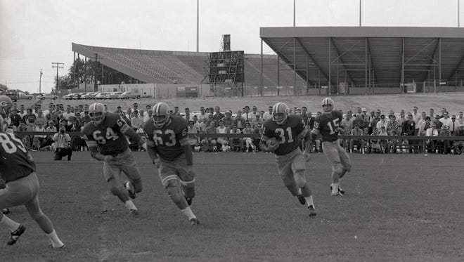 Green Bay Packers fullback Jim Taylor (31) carries the ball on the sweep, led by guards Jerry Kramer (64) and Fuzzy Thurston (63) during a training camp scrimmage on the team's practice field across from new City Stadium on July 26, 1962. Quarterback Bart Starr (15) is at right. Press-Gazette archives