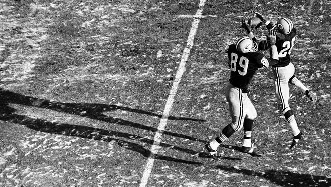 Packers cornerback Herb Adderley (26) intercepts a Don Meredith pass during the second quarter of the Packers' 21-17 victory over the Dallas Cowboys in the Ice Bowl. Linebacker Dave Robinson is at left.