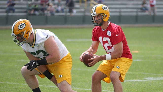 Green Bay Packers quarterback Aaron Rodgers (12) takes a snap from center Corey Linsley (63) during Green Bay Packers Organized Team Activities at Ray Nitschke Field Tuesday, May 22, 2018 in Ashwaubenon, Wis