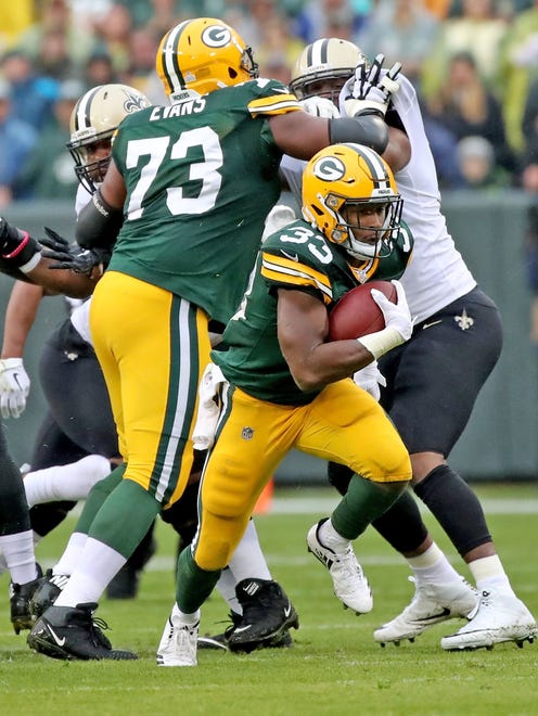 Green Bay Packers running back Aaron Jones (33) breaks into the open for a long touchdown run as offensive guard Jahri Evans (73) blocks in the first quarter against the New Orleans Saints on Oct. 22, 2017, at Lambeau Field in Green Bay.