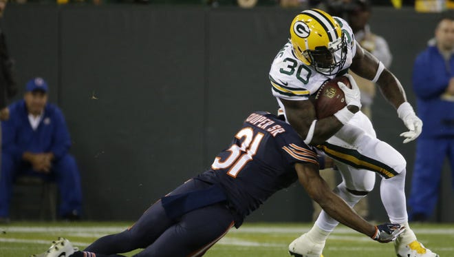 Green Bay Packers running back Jamaal Williams (30) picks up four yards before being tackled by Chicago Bears cornerback Marcus Cooper (31) during the first quarter on Sept. 28, 2017, at Lambeau Field.
