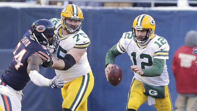 Green Bay Packers quarterback Aaron Rodgers (12) scrambles up the middle as tackle Bryan Bulaga (75) blocks against the Chicago Bears on Dec. 18, 2016, at Soldier Field.