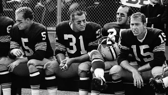 From left, Green Bay Packers halfback Paul Hornung (5), fullback Jim Taylor (31), end Max McGee (85) and quarterback Bart Starr (15) sit on the sidelines during a 49-0 victory over the Chicago Bears at new City Stadium on Sept. 30, 1962.