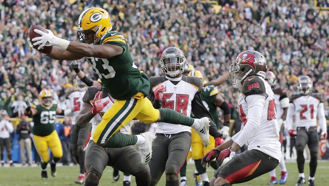 Green Bay Packers running back Aaron Jones (33) dives into the end zone to score the game-winning touchdown in overtime against the Tampa Bay Buccaneers on Dec. 3, 2017, at Lambeau Field.