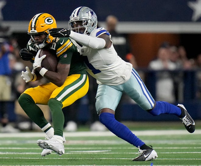 Green Bay Packers wide receiver Romeo Doubs (87) is tackled by Dallas Cowboys safety Jayron Kearse (1) after a 26-yard reception during the first quarter of the wild card playoff game Sunday, January 14, 2024 at AT&T Stadium in Arlington, Texas.