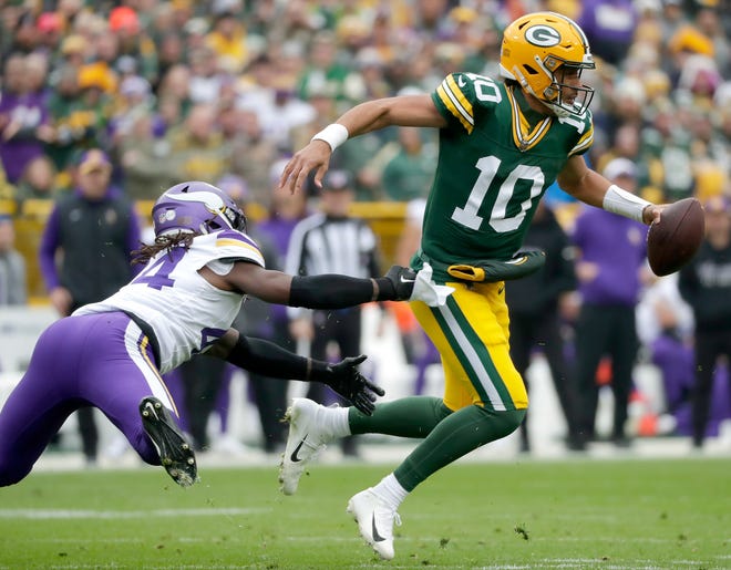 Green Bay Packers quarterback Jordan Love (10) is chased by Minnesota Vikings safety Josh Metellus (44) during their football game on, Oct.29, 2023, at Lambeau Field in Green Bay, Wis. Minnesota defeated Green Bay 24-10.