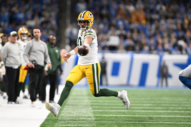 Green Bay Packers quarterback Jordan Love (10) stretches the ball out for extra yardage as he runs out of bounds against the Detroit Lions in the first quarter at Ford Field on Nov. 23, 2023.