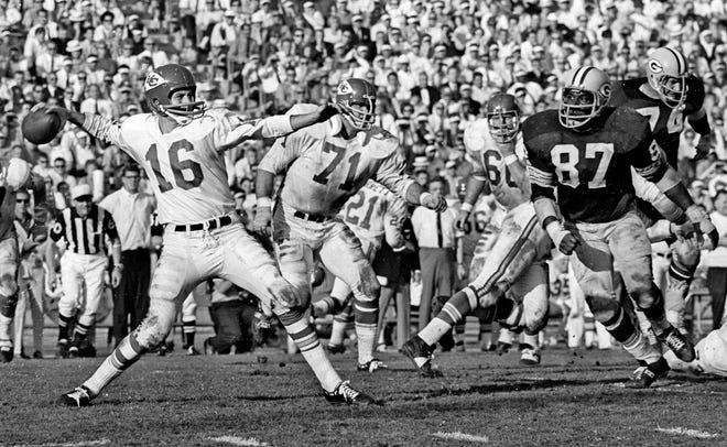 1967: Chiefs' Len Dawson passes during the first Super Bowl game at Memorial Coliseum. Also in this image are Chiefs guard Ed Budde, 71, and Packers defensive end Willie Davis, 87.
