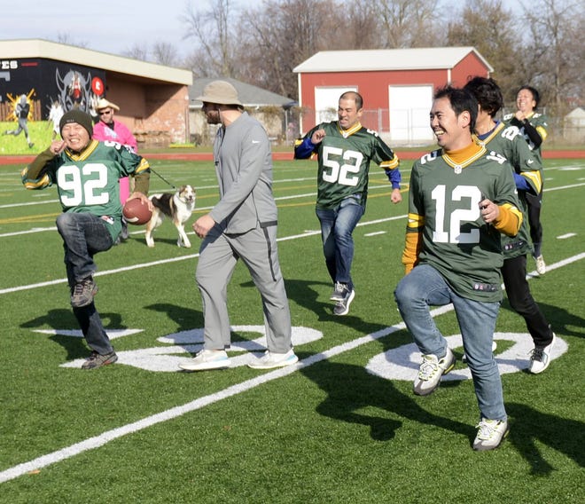 Brian Gajeski of Bode Central, Howard, in grey, conducts warm-up drills with Japanese Packers Cheering Team members on Nov. 9, 2019, at Green Bay East High School.