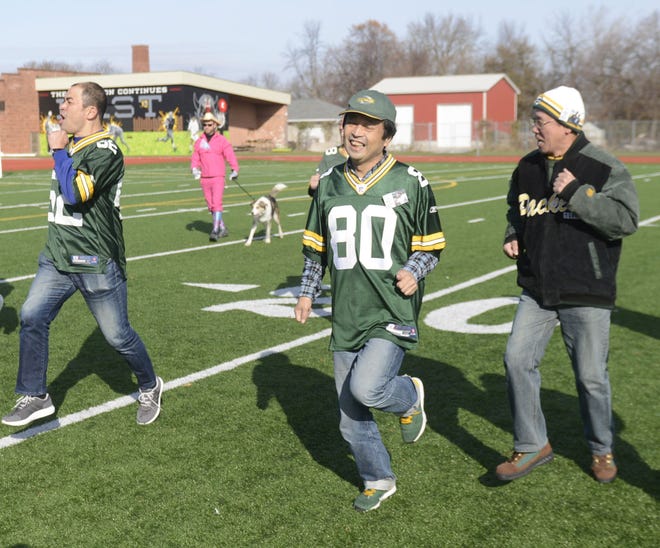 Takashi “Cheppo” Kawarazaki, center, and Masahiro "Suh" Sugizaki, right, of the Japanese Packers Cheering Team do warm-up drills on Nov. 9, 2019 at Green Bay East High School.
