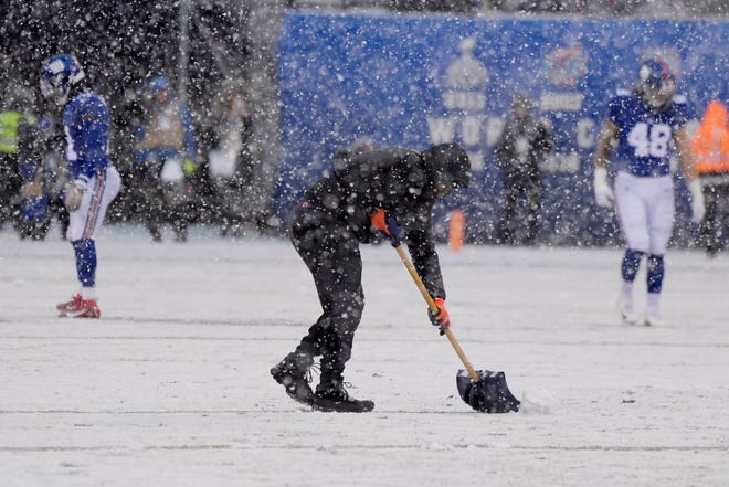 A man shovels the field during the first half of an NFL football game between the New York Giants and the Green Bay Packers, Sunday, Dec. 1, 2019, in East Rutherford, N.J. (AP Photo/Bill Kostroun)