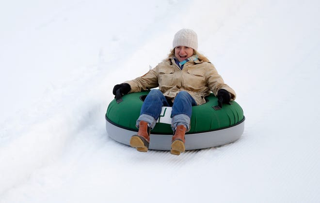 Alison Duke of Barrington smiles as she rides a snow tube down Ariens Hill on Jan. 3. This year's Ariens Free Tubing Night is Feb. 4.