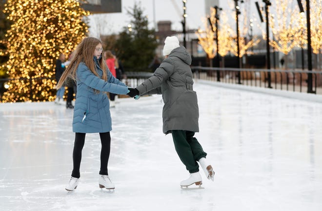 Reese Nystrom and Paisley Wyrzykiewicz of Green Bay ice skate together on the rink at the Titletown District. Free skate lessons are part of the programming this winter.
