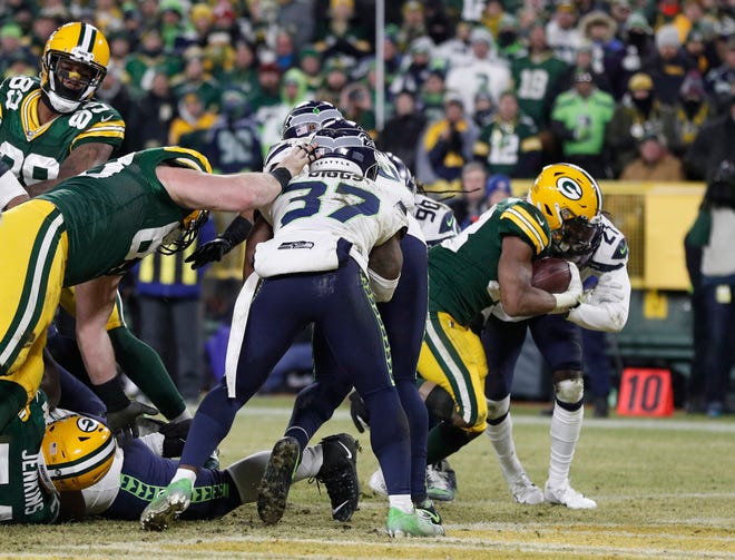 Green Bay Packers running back Aaron Jones (33) scores a touchdown against the Seattle Seahawks in the second quarter of a NFC Divisional Round playoff football game at Lambeau Field on Sunday, January 12, 2020 in Green Bay, Wis.
