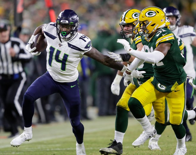 Seattle Seahawks wide receiver D.K. Metcalf (14) runs for a first down on a reception against Green Bay Packers strong safety Adrian Amos (31) in the third quarter during their NFC divisional round playoff football game on Sunday, January 12, 2020, at Lambeau Field in Green Bay, Wis.
