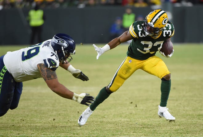 Green Bay Packers running back Aaron Jones (33) is tackled by Seattle Seahawks nose tackle Bryan Mone (79) in the second quarter of a NFC Divisional Round playoff football game at Lambeau Field on Sunday, January 12, 2020 in Green Bay, Wis.