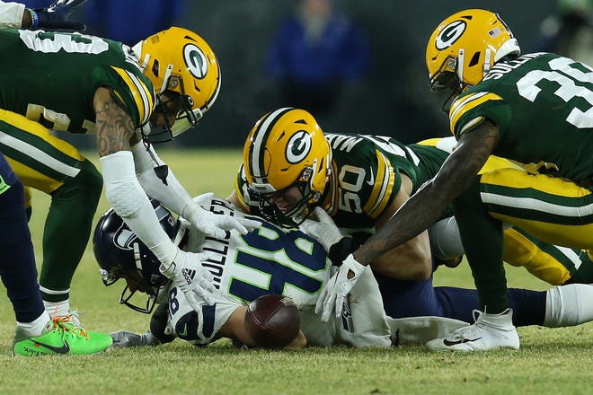 Blake Martinez #50 of the Green Bay Packers and teammates try to recover the ball after hitting Jacob Hollister #48 of the Seattle Seahawks in the first quarter of the NFC Divisional Playoff game at Lambeau Field on Sunday, January 12, 2020 in Green Bay, Wis.
