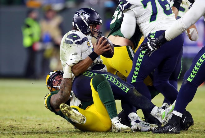 Preston Smith #91 of the Green Bay Packers sacks Russell Wilson #3 of the Seattle Seahawks during the fourth quarter in the NFC Divisional Playoff game at Lambeau Field on January 12, 2020 in Green Bay, Wisconsin.