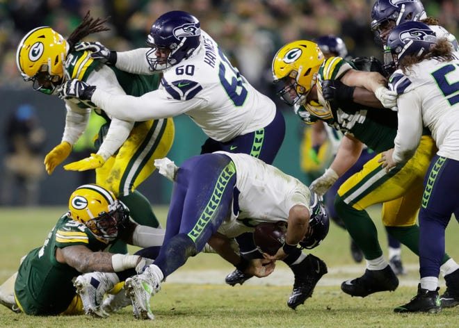 Green Bay Packers outside linebacker Preston Smith (91) sacks Seattle Seahawks quarterback Russell Wilson (3) early in the fourth quarter during their NFC divisional round playoff football game on Sunday, January 12, 2020, at Lambeau Field in Green Bay, Wis.