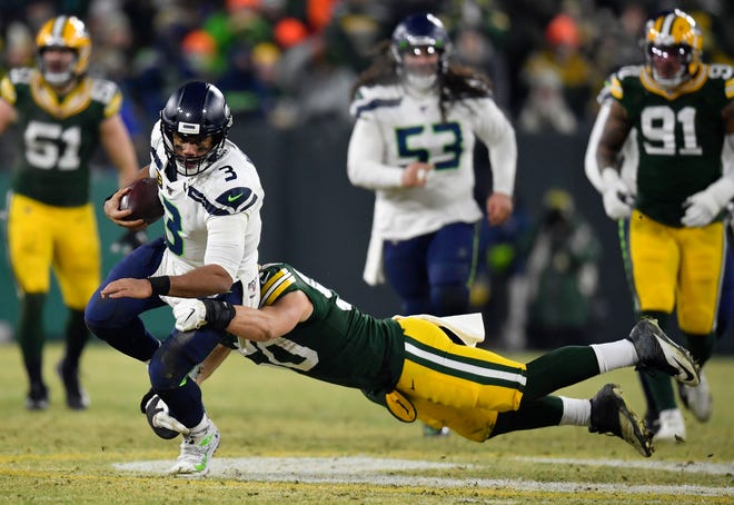 Russell Wilson #3 of the Seattle Seahawks runs the ball as he is tackled by Blake Martinez #50 of the Green Bay Packers in the second quarter of the NFC Divisional Playoff game at Lambeau Field on January 12, 2020 in Green Bay, Wis.