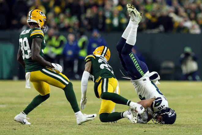 Jacob Hollister #48 of the Seattle Seahawks loses the ball as he is upended by Jaire Alexander #23 of the Green Bay Packers during the first quarter in the NFC Divisional Playoff game at Lambeau Field on Sunday, January 12, 2020 in Green Bay, Wis. Hollister was ruled down upon review.