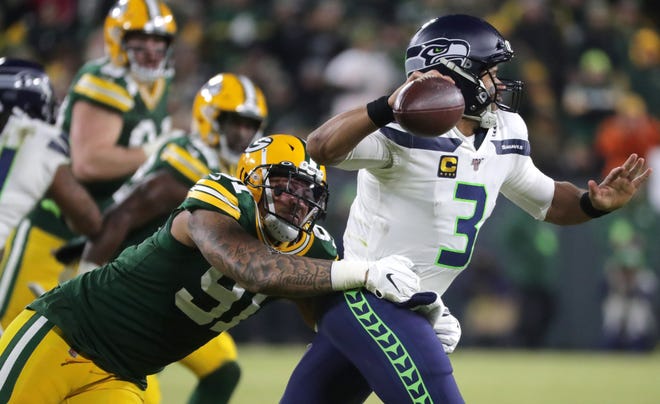 Green Bay Packers outside linebacker Preston Smith (91) presses Seattle Seahawks quarterback Russell Wilson (3) during the third quarter of their divisional playoff game Sunday, January 12, 2020 at Lambeau Field in Green Bay, Wis. The Green Bay Packers beat the Seattle Seahawks 28-23.