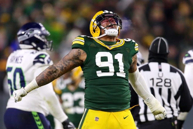 Preston Smith #91 of the Green Bay Packers celebrates after sacking Russell Wilson #3 of the Seattle Seahawks (not pictured) during the fourth quarter in the NFC Divisional Playoff game at Lambeau Field on January 12, 2020 in Green Bay, Wisconsin.