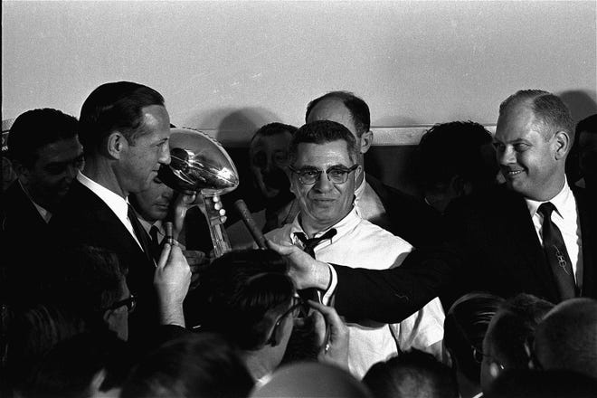 Football commissioner Pete Rozelle, left, presents the trophy to Coach Vince Lombardi of the Green Bay Packers in Los Angeles Jan. 15, 1967, after the Packers trounced the Kansas City Chiefs 35 to 21 in the first Super Bowl football game.