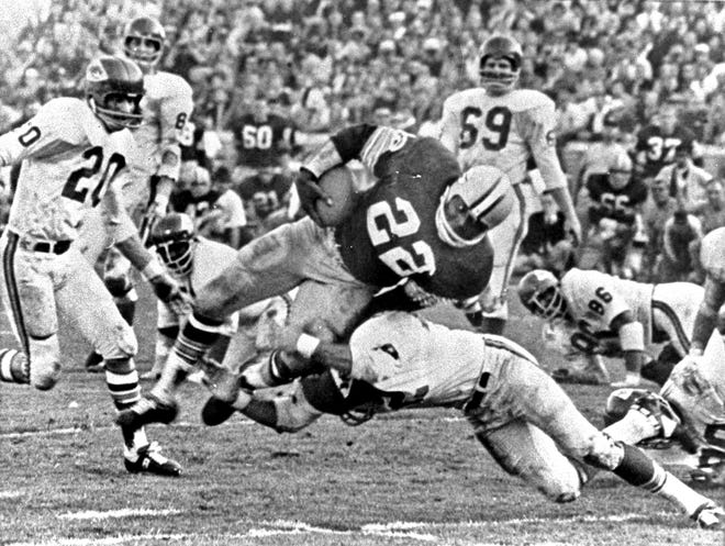 In this Jan. 15, 1967, file photo, Green Bay Packers' Elijah Pitts (22) goes over right tackle to the Kansas City Chiefs' five-yard line for a six-yard gain before being brought down by Kansas City's Johnny Robinson in the fourth quarter of  Super Bowl I in Los Angeles.  Three plays later Pitts went over for the touchdown. The Packers beat the Chiefs 35-10.  Looking on are Chiefs Bobby Hunt (20) and Sherrill Headrick (69).