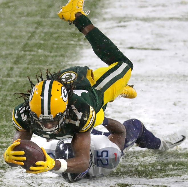 Green Bay Packers wide receiver Davante Adams (17) dives to the end zone over the defense of Tennessee Titans cornerback Adoree' Jackson (25) during the Packers' opening drive on Sunday, December 27, 2020, at Lambeau Field in Green Bay, Wis.