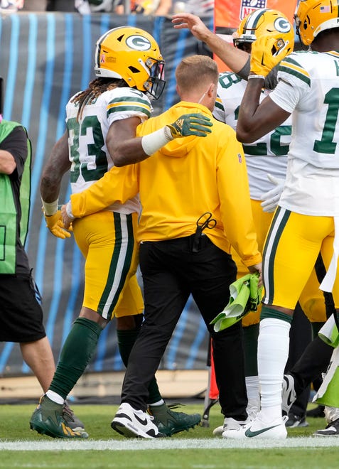 Green Bay Packers running back Aaron Jones (33) is helped on the sideline after scoring a touchdown during second half of their game on Sunday, Sept. 10, 2023 at Soldier Field in Chicago.
