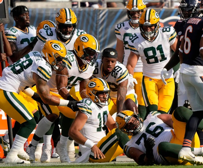 Green Bay Packers quarterback Jordan Love (10) is surrounded by teammates on the sideline after rushing for a gain during second quarter of their game against the Chicago Bears on Sunday, Sept. 10, 2023 at Soldier Field in Chicago.